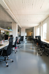 Shot of empty desks and seats in a coworking space.