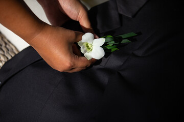 Orchid flower embroidered on a black suit with meticulousness and determination The colors of light...