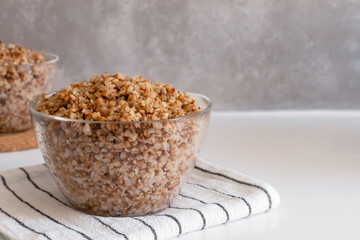 boiled buckwheat porridge in a transparent glass bowl copy space