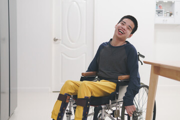 Teenager boy with disability with happy face in living room at the home or hospital or...