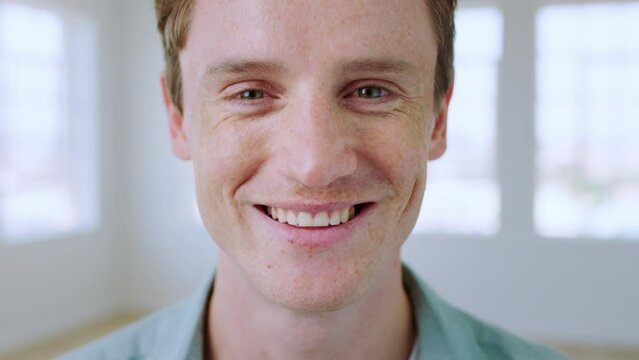 Face, man and smile for happiness, kindness and humanity while in a bright room showing perfect teeth for dental marketing. Portrait of friendly London male with freckles, happy and positive mindset
