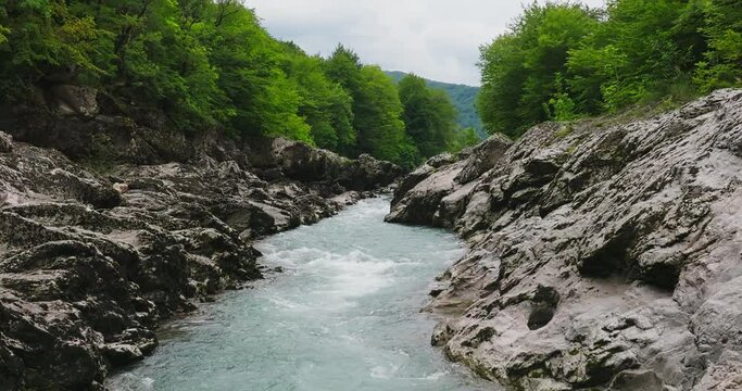 Aerial view of Mountain river and road. Flying over a mountain gorge. Slow motion 120 fps.