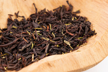 Dried black tea leaves with thyme herb in rustic wooden bowl