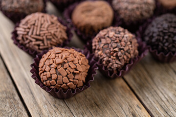 Typical brazilian chocolate brigadeiros over wooden table, short depth of field