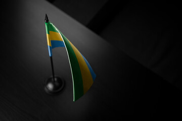 Small national flag of the Gabon on a black background