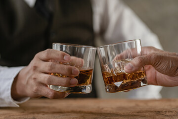Two young men drinking whiskey in restaurant celebrating successful deal, joint business concept.