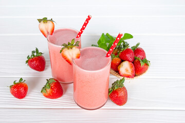 Strawberry yogurt fruit juice smoothie pink colorful fruit juice milkshake blend beverage healthy high protein the taste yummy In glass drink episode morning on white wood background.