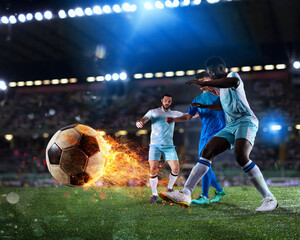 Football scene with competing football players at the full stadium with a fireball