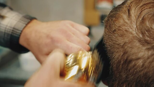 Barbershop. Men's haircut in detail. Close-up of a barber's hand. Barbershop. The man is doing a haircut. Close-up master's tools, comb, scissors, trimer.