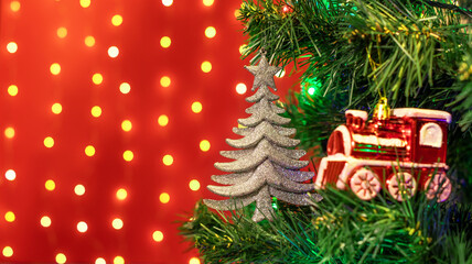 Christmas decorations hung on a Christmas tree against a red background.
Ozdoby choinkowe zawieszone na choince na czerwonym tle.