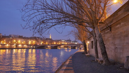 Promenade au bord de la Seine pendant une soirée, début saison d'automne, éclairé par des...
