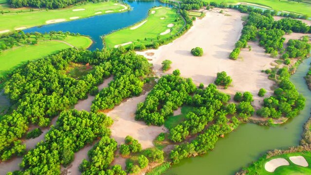 Aerial view over beautiful golf field landscape during sunset. hobby and sports concepts. Tropical golf course in Southeast asia. summer day. green nature background. drone footage. cinematic shot 4K
