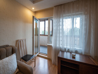 Modern interior of living room in apartment. Wooden furniture.  Door to balcony.