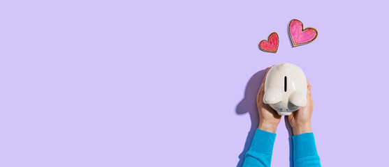 Person holding a piggy bank with hearts