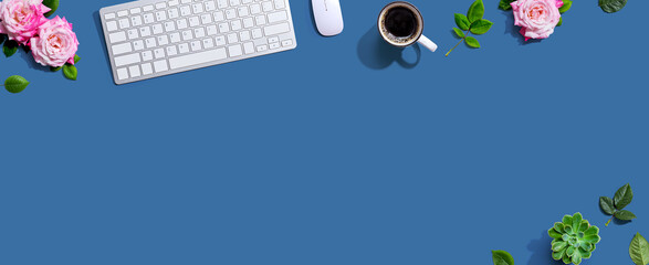 Computer keyboard and a mouse with pink roses - flat lay