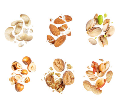 Set of various crushed dried nuts close-up in the air isolated on a white background