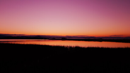 Beach island sunset Sao Francisco do Sul with purple sky, lake, native grass.