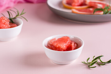 Peeled pieces of grapefruit and rosemary in a bowl on the table. Cocktail ingredients.