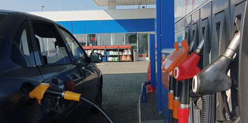 Pumping equipment gas at gas station. Close up of fuel nozzle. Pumping Expensive Gasoline into Gas Tank.