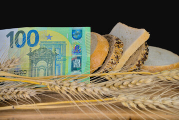 One hundred euro bill and slices of bread and ears of wheat