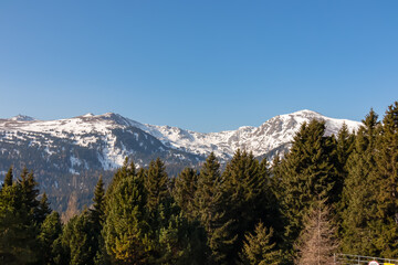 Panoramic view of forest and snow capped mountain peak Zirbitzkogel and Kreiskogel in Seetal Alps, Styria (Steiermark), Austria, Europe. Alpine hiking trail in Central Alps in winter on sunny day