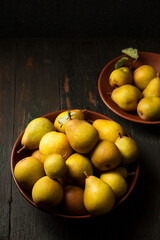 Delicious juicy homemade pears in clay plates in rustic style.