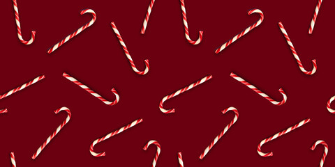 Seamless pattern with Christmas candies on bright maroon background. Creative minimal X mas art. Copy space. Flat lay.