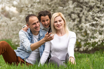 Fototapeta premium Family and small child outdoors in spring nature, resting.