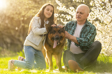 Smiling child hugging her happy grandfather - outdoor in nature.