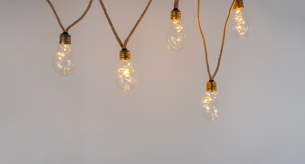 Banner with a hanging LED light chain made of light bulbs in retro look. Concept for creativity, ideas, problem solving, cosiness, party.