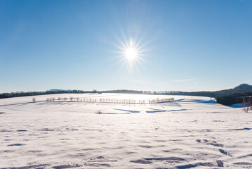 winter landscape with snow, sun and blue sky