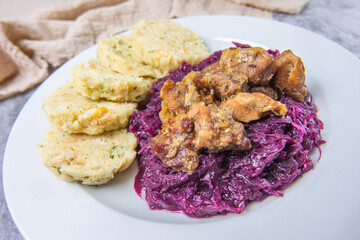 Roast pork with dumplings and sauerkraut. Typical Czech national meal with homemade bread dumplings red cabbage on stone background.