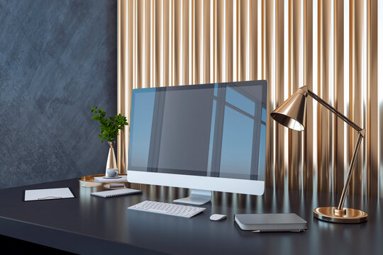 Perspective view on modern computer monitor on dark office table with notebook, flower coffee pot on golden slatted decorative wall panel background. 3D rendering