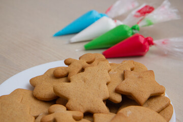 Christmas gingerbread in a plate and colored icing in bags