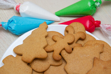 Christmas gingerbread in a plate and colored icing in bags