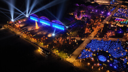 Aerial drone night distant shot from illuminated with Christmas lights futuristic Ellinikon Experience public Park an urban regeneration project and cultural center in Athens riviera, Attica, Greece