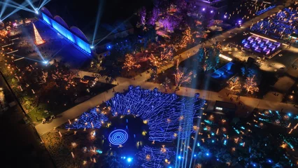 Fotobehang Aerial drone night distant shot from illuminated with Christmas lights futuristic Ellinikon Experience public Park an urban regeneration project and cultural center in Athens riviera, Attica, Greece © aerial-drone