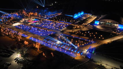 Aerial drone night distant shot from illuminated with Christmas lights futuristic Ellinikon Experience public Park an urban regeneration project and cultural center in Athens riviera, Attica, Greece