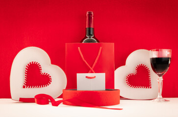 Fond d'écran pour la Saint-Valentin avec des cœurs rouges et du vin rouge. Composition romantique...