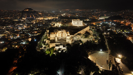 Aerial drone night shot of iconic illuminated landmark Acropolis hill and the Masterpiece of Ancient times and Western civilisation - the Parthenon, Athens historic centre, Attica, Greece