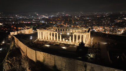 Fototapeta na wymiar Aerial drone night shot of iconic illuminated landmark Acropolis hill and the Masterpiece of Ancient times and Western civilisation - the Parthenon, Athens historic centre, Attica, Greece
