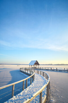 curved footbridge over frozen lake in Hemmelsdorf, northern Germany. High quality photo