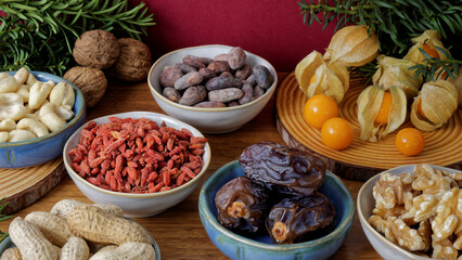 Assortment of healthy snacks: fruits and nuts on winter decorated table.