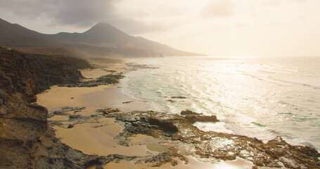 Amazing famous golden sand Cofete beach with endless horizon. Deserted volcanic hills in the background and Atlantic Ocean. Fuerteventura Canary Islands Spain. Playa de Cofete.