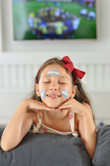 menina comemorando argentina campeã do mundo de futebol comemoração assistindo tv rosto pintado 