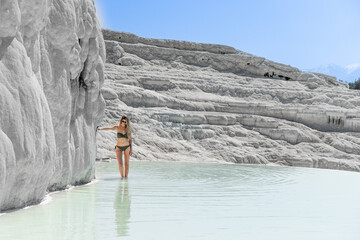 Blonde pretty woman with swimwear at Natural travertine pools and terraces in Pamukkale Turkey