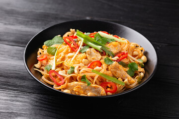 Chicken Pad Thai with eggs, bean sprouts, peanuts and spring onion.