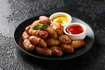 Pigs in blankets with ketchup and mustard sauce. Party food