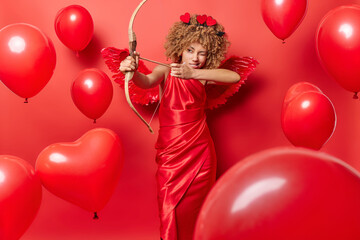 Serious woman in role of cupid shoots arrow wears elegant dress tries to find love brings happiness...