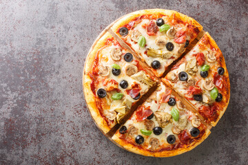 Italian delicious capricciosa pizza with aritichokes, prosciutto ham, olives, champignons and cheese close-up on a wooden board on the table. Horizontal top view from above